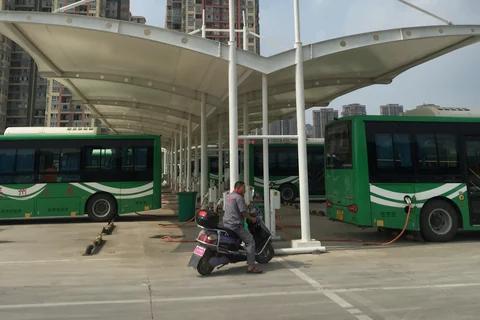 膜结构充电棚实拍,棚下停放电动公交车,可见充电线缆