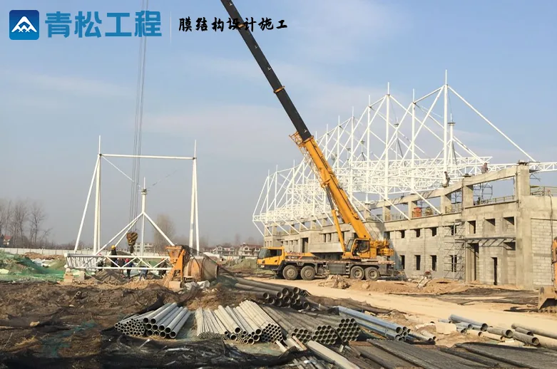 Lifting grandstand steelwork, with components stored on the ground