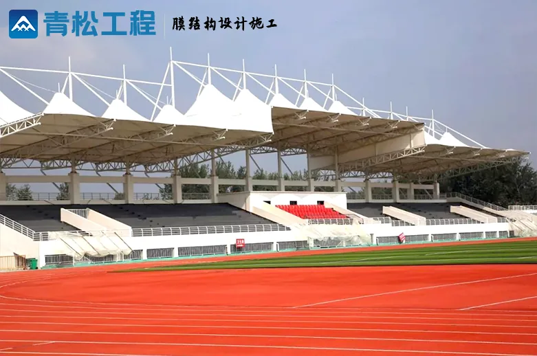 Luyi stadium grandstand with repeating pointed membrane roof units beside the running track