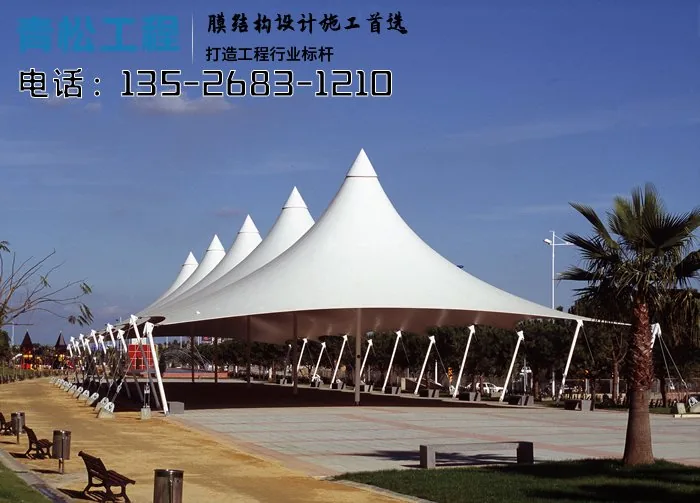 Repeated peaked membrane canopies and external supports beside a plaza