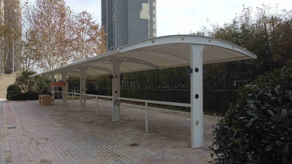 Double-sided carport with a central line of columns and white membrane coverage