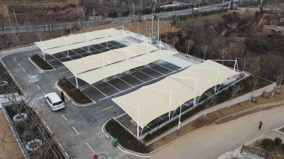 Xingyang parking area with grouped membrane carports, marked bays and driveways