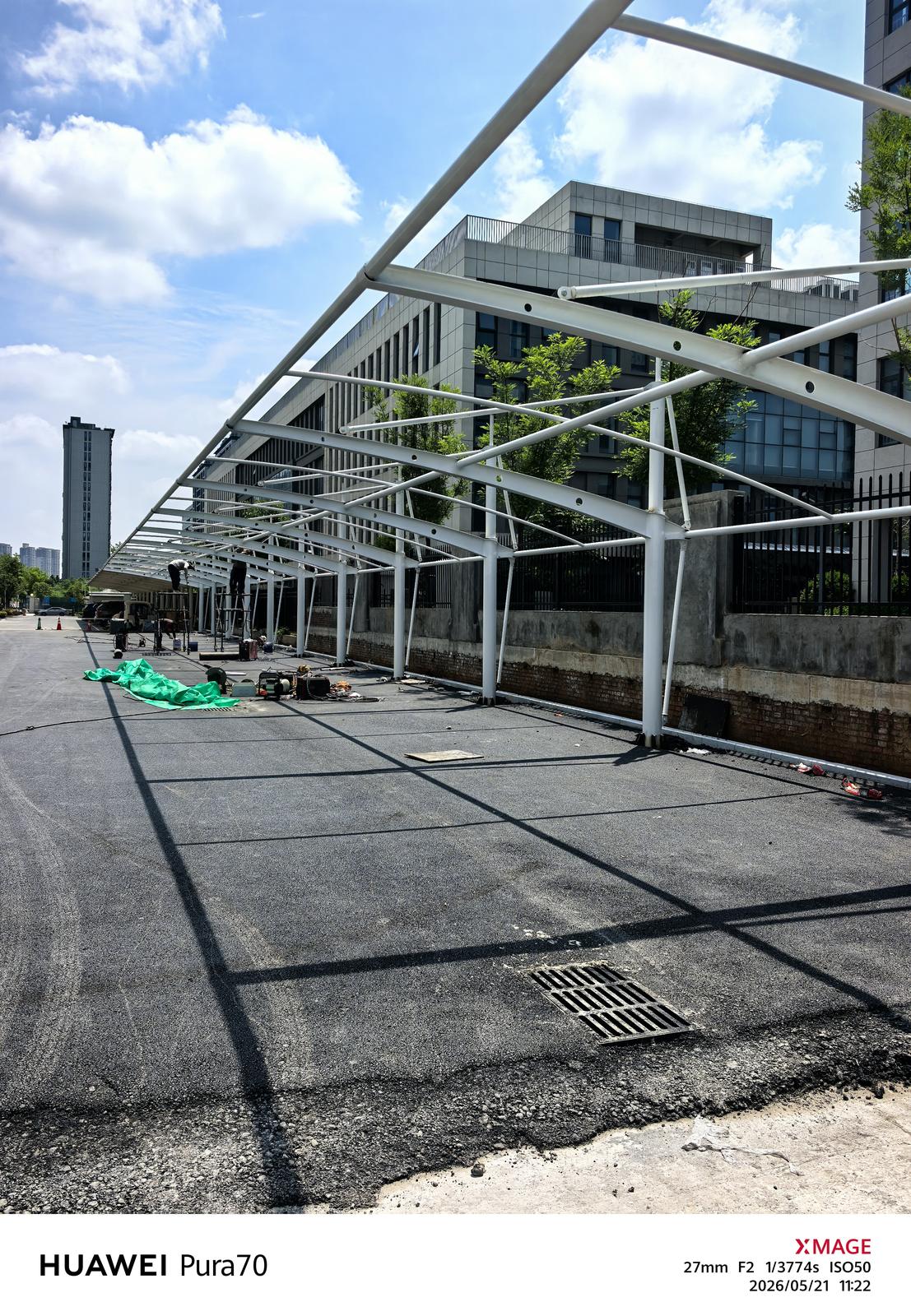 郑州高新区建筑旁拉杆式车棚的白色骨架