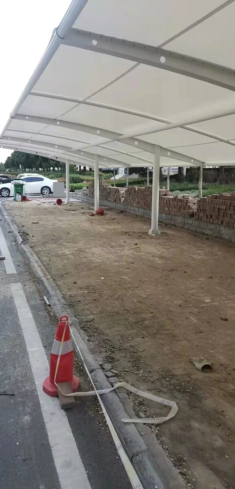 郑州金水区单排拉杆膜结构停车棚下方的白色梁柱与膜面