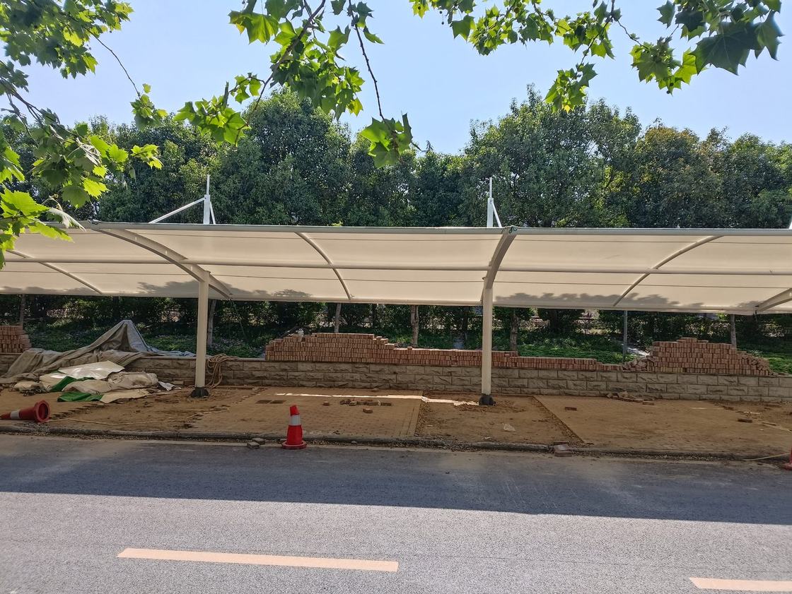 郑州金水区道路旁白色拉杆膜结构车棚及后方树列