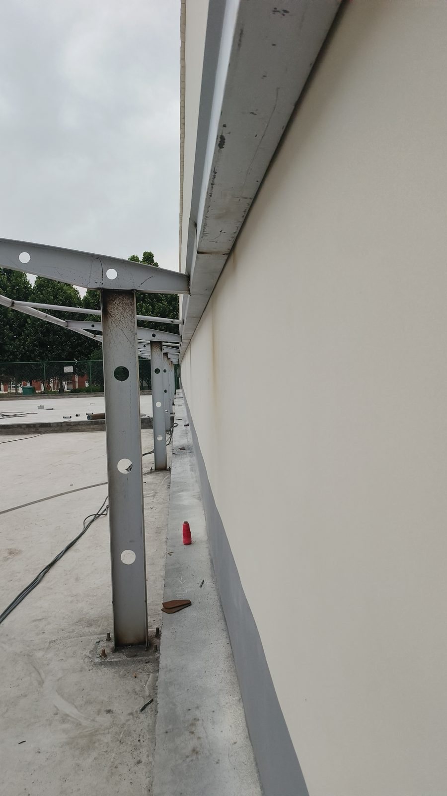 Columns, cantilever arms and base connections beside the wall