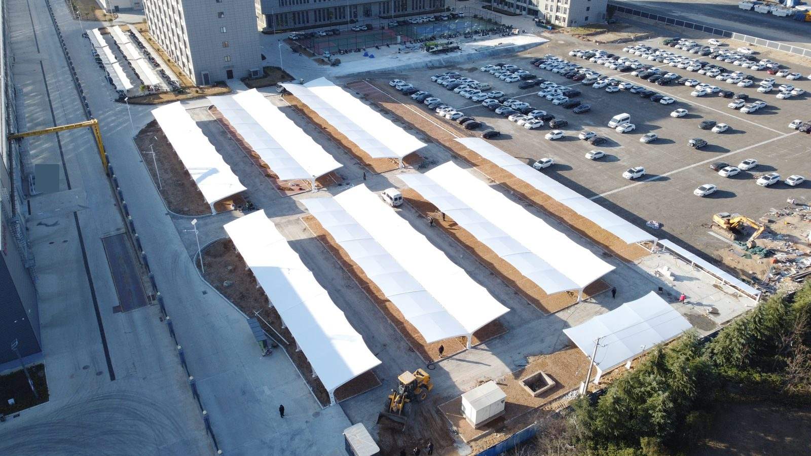 郑州中牟厂区双侧膜结构停车棚从厂房道路侧的全场斜俯视